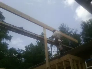 Carpenter setting a ridge beam over a new addition frame — Ice Dam Removal by Roofing Brothers in Table Rock