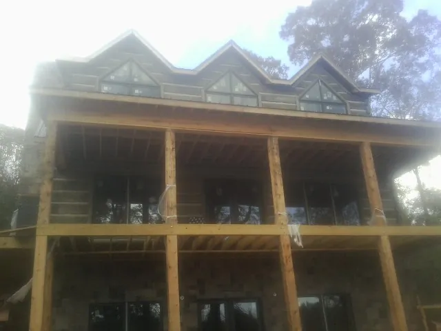 Dormers and porch framing on a large log home under construction — Roof Coating work by our crew in Table Rock