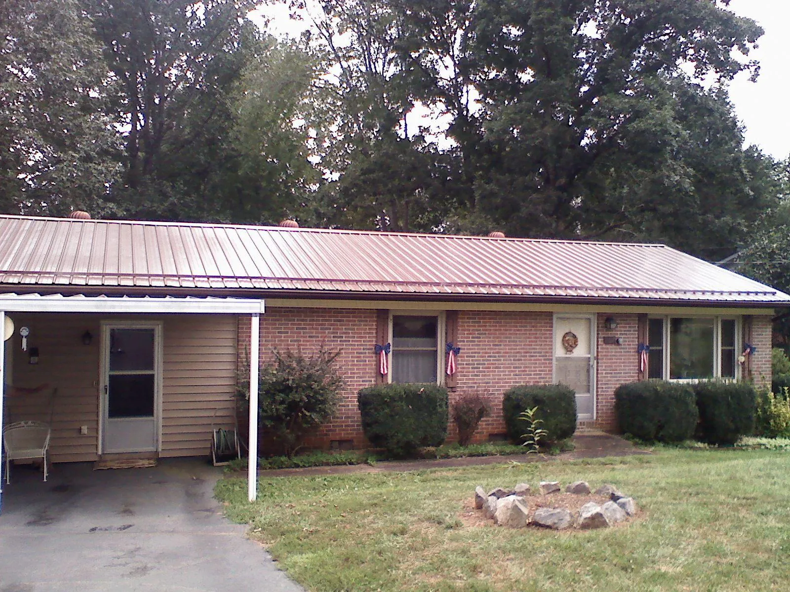 Bronze metal roof and carport on a brick ranch home — Roof Repair work by our crew in Table Rock